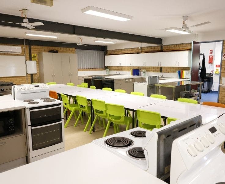 View of the new school kitchen classroom with a stove top in the foreground