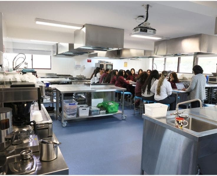Class in progress in a stainless steel industrial kitchen