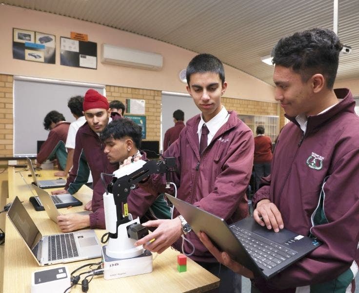 Students programming a multi-axis robotic arm
