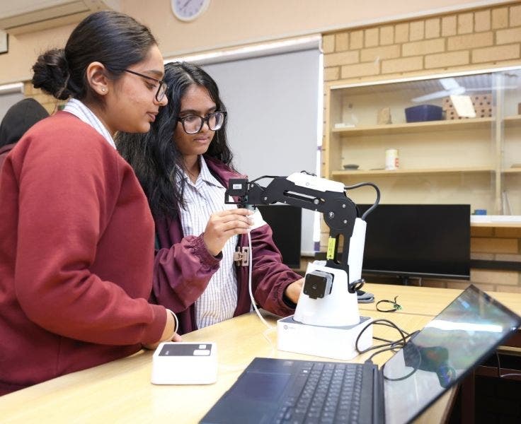 Students programming a multi-axis robotic arm