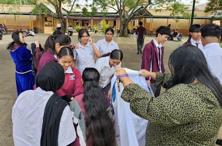 Ms Ingale hands out costumes so year 11 students studying Macbeth can get into character