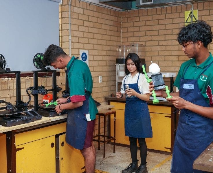 Students using a 3D printer to assemble a robot model