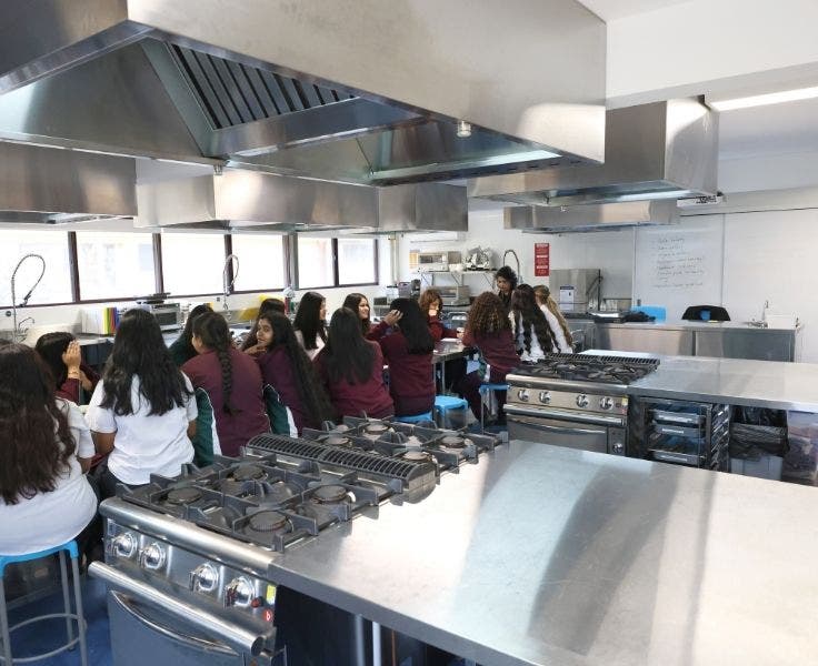 Class in progress in a stainless steel industrial kitchen